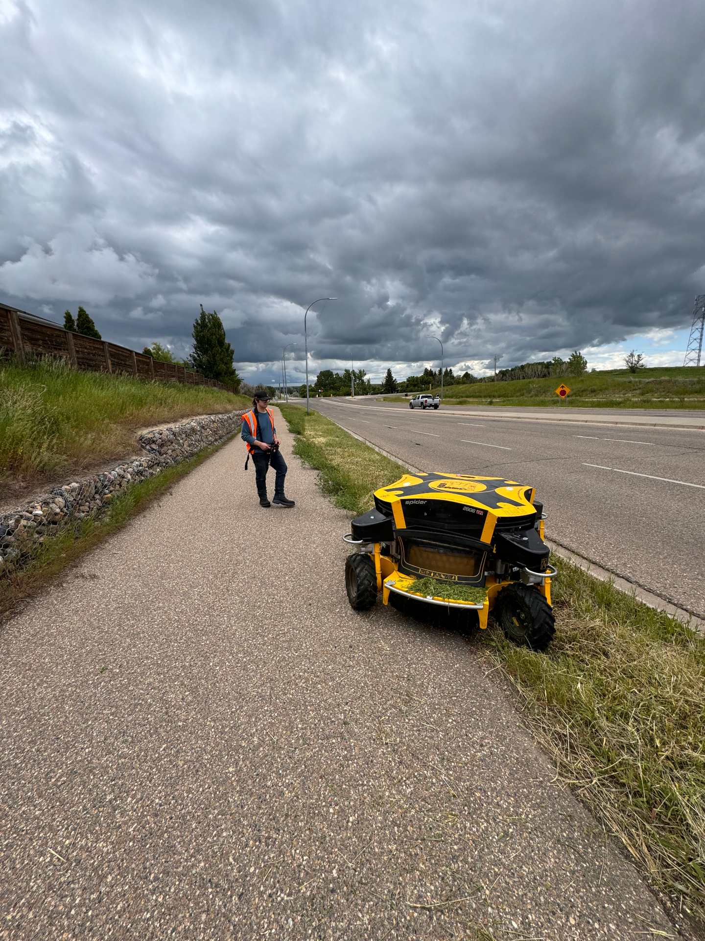 Remote-controlled robotic slope mower on a roadside berm