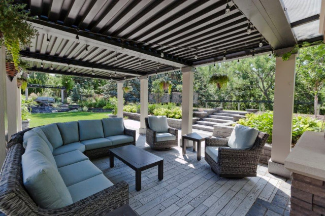 Covered outdoor living room with sectional under louvered pergola