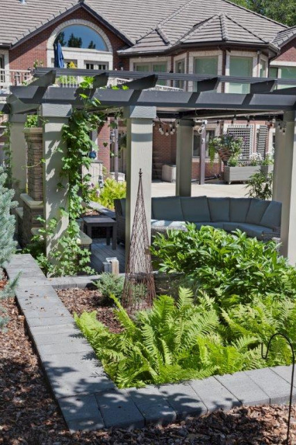 Pergola adjacent to a lush fern bed and stone path