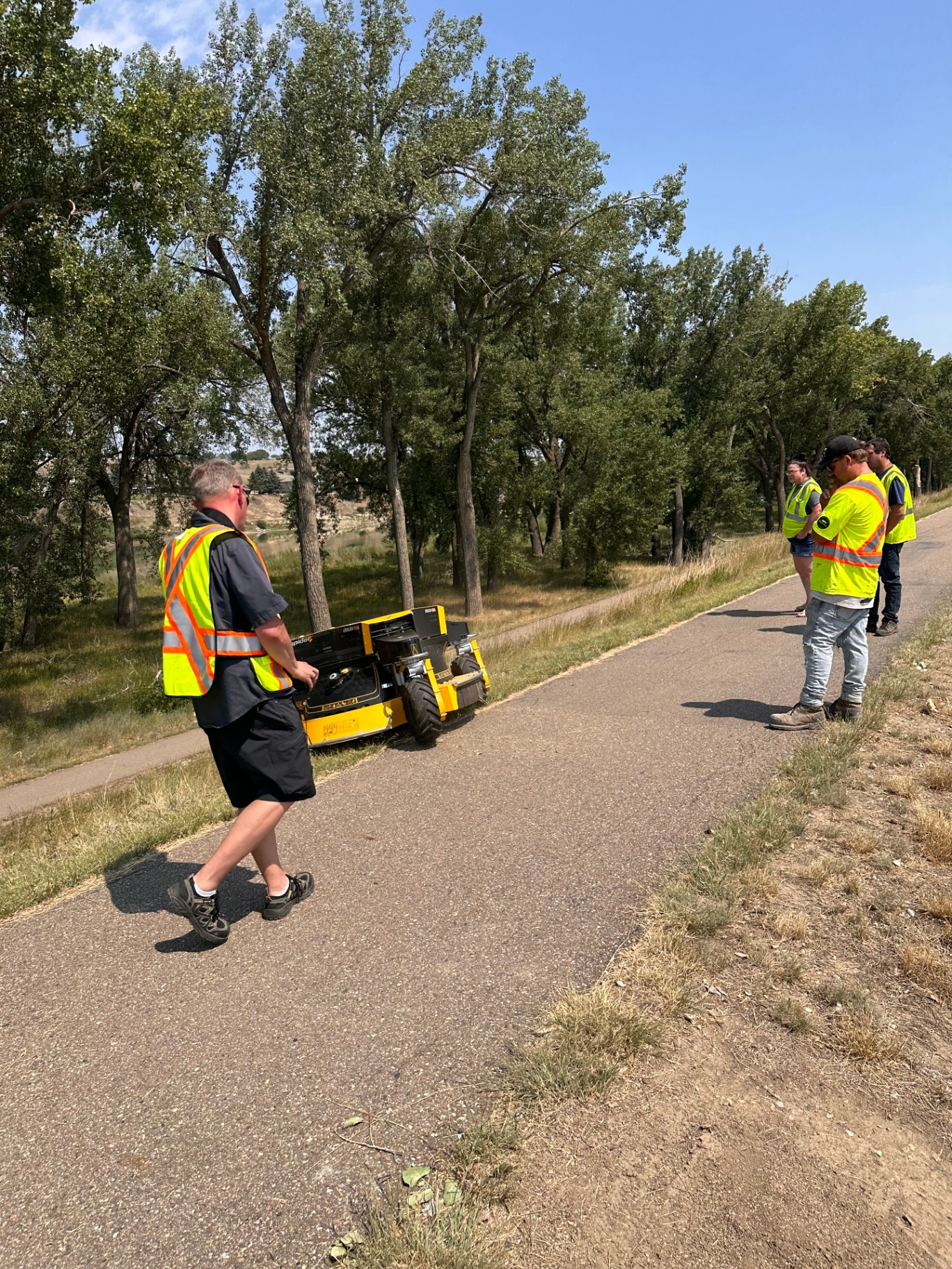 Avara crew operating a remote-controlled slope mower for vegetation management at a renewable energy site